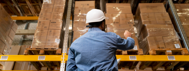 Trabajador de almacén señalando cajas