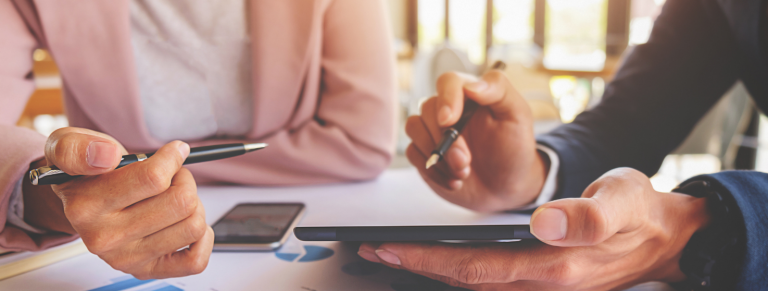 personas señalando las cuentas a pagar en una tableta