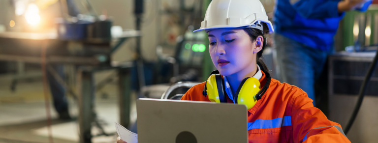 Trabajadora con EPI atendiendo al ordenador