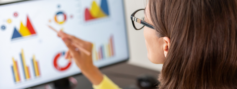 Mujer señalando gráficos en una pantalla de ordenador