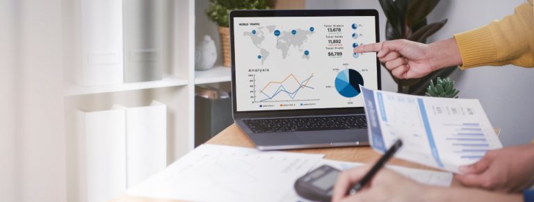Persona señalando gráfico en portátil de KPI de producción