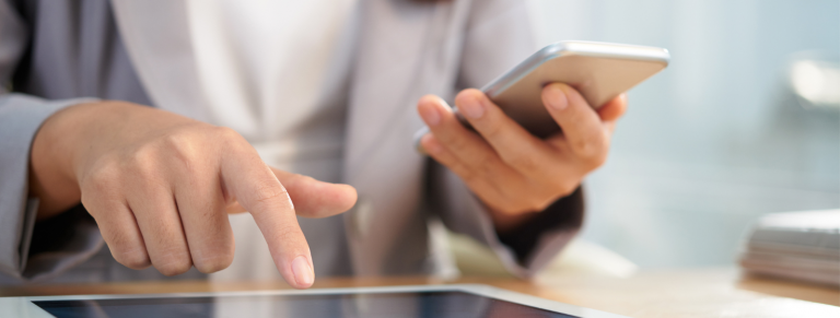 Persona trabajando con tableta y teléfono